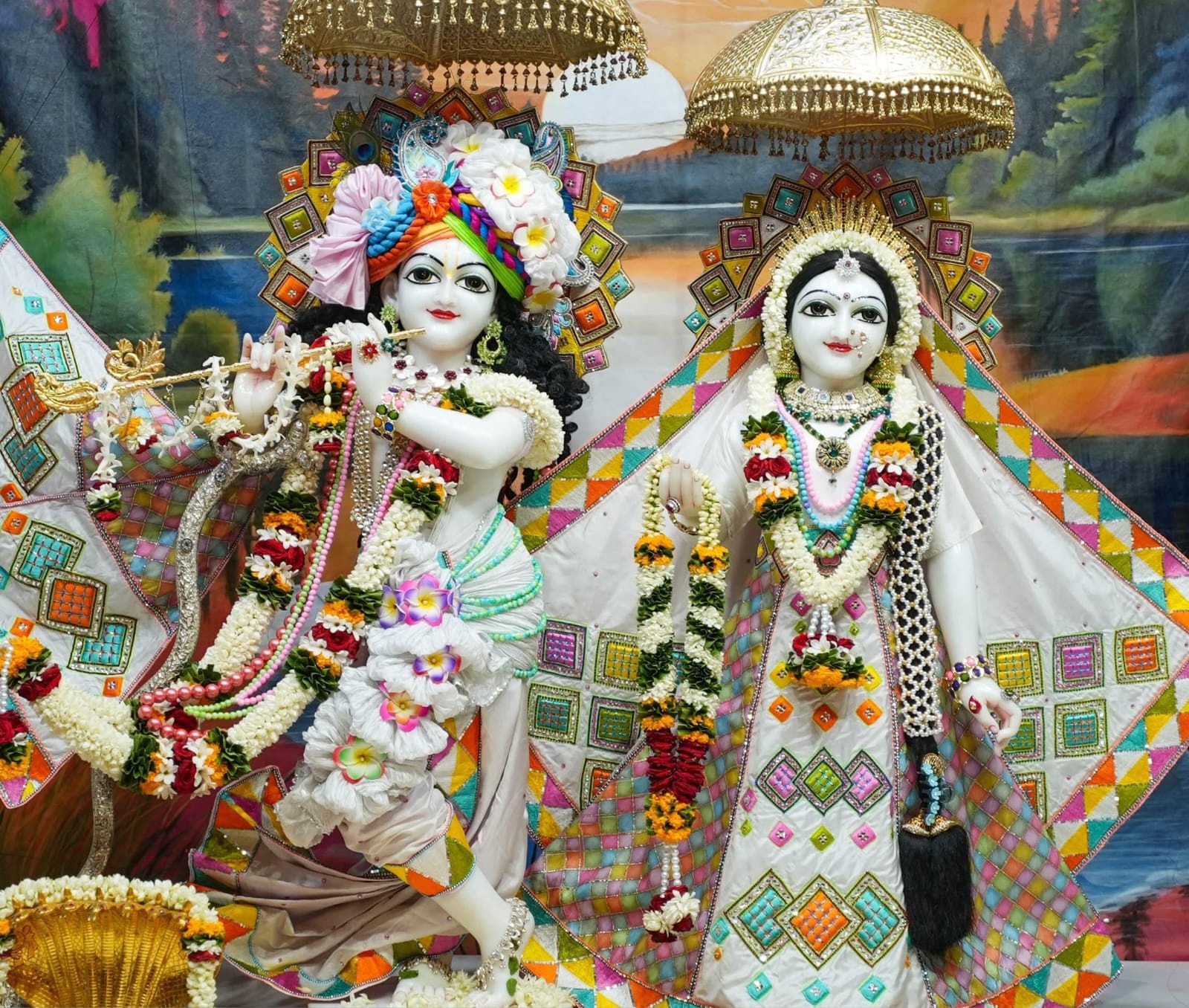 Radha and Krishna deities dressed and garlanded for darshan